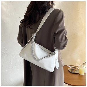 Gros plan d'un sac sous les bras en cuir blanc avec chaîne argentée et fermeture