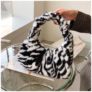 Détail d'un sac à main en peluche motif zèbre sur table en verre pour la mode automne-hiver
