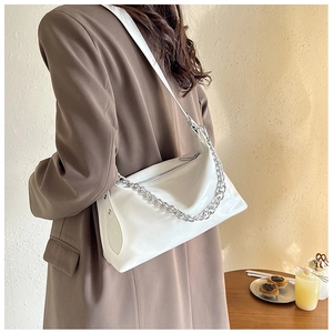 Vue détaillée d'un grand sac à bandoulière blanc avec une chaîne argentée décorative