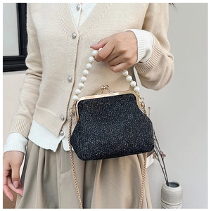 Detail of black sequined evening bag with pearl handle and golden chain strap