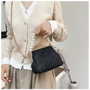 Detail of vintage black glitter evening bag with pearl handle and golden chain
