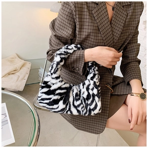 Détail du sac à bandoulière en peluche zébré associé à un blazer à carreaux marron chic