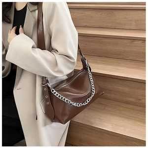Détail du sac bandoulière en cuir PU marron chocolat avec chaîne argentée et œillets