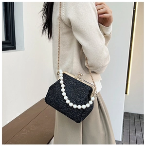 Macro shot of retro black sequined handbag with white pearl handle and golden chain