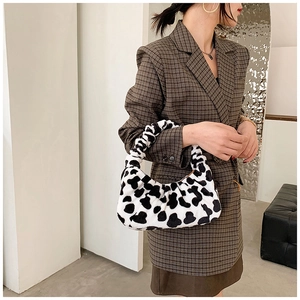 Détail du sac bandoulière en peluche zébré montrant la texture douce et la forme en croissant