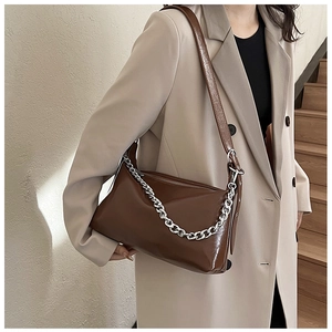 Sac à épaule en cuir marron avec chaîne argentée et bandoulière réglable sur le mannequin