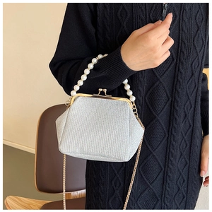 Detail of silver glitter clutch bag featuring pearl handle and vintage metal clasp