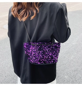 Close-up of shiny purple sequin crossbody bag with a slim black metal chain strap