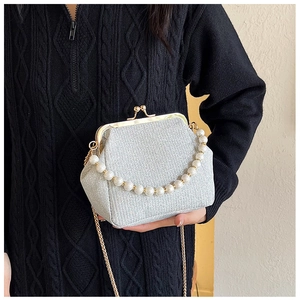 Silver glitter frame bag detail featuring large round pearl handle and gold chain