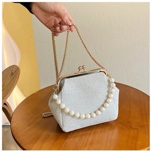 Close-up of vintage evening bag with silver glitter fabric, pearl handle and gold clasp