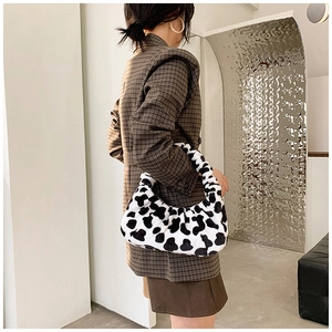 Sac à bandoulière chic en peluche à motif zèbre porté par un mannequin en intérieur