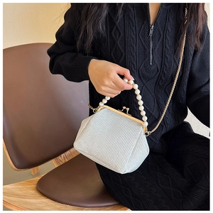 Detail of silver glitter kiss-lock bag with pearl handle and golden chain strap