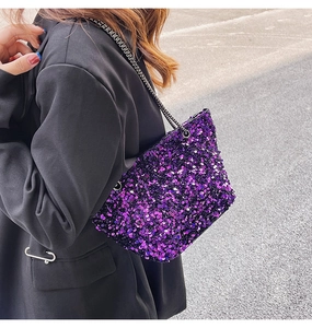 Detail of a purple sequin chain shoulder bag worn with a black blazer for a party look