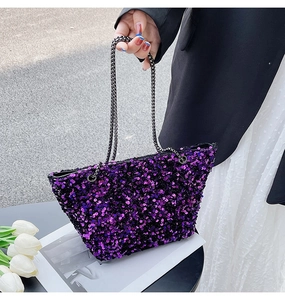 Close-up of purple sequin handbag featuring metallic gunmetal chain strap detail