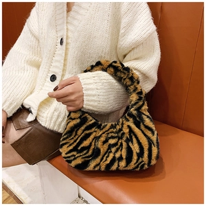 Gros plan détaillé montrant la texture douce en fausse fourrure tigre du sac à bandoulière