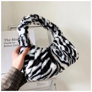 Détail de la texture en fausse fourrure zébrée d'un sac à bandoulière chic automne-hiver