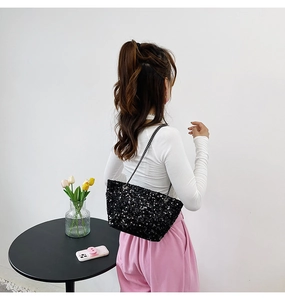 Detailed view of black sequin shoulder bag with elegant silver metal chain strap for women