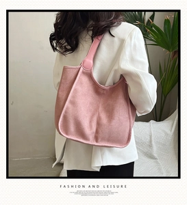 Pink faux suede tote bag on model shoulder with white suit for casual work style