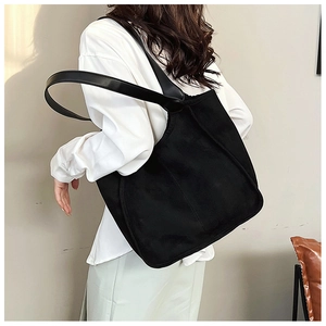 Minimalist black plush tote bag shown on model for a casual and stylish commute look