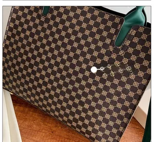 Top-down close-up of a vintage tote bag with geometric clover pattern and green leather handles