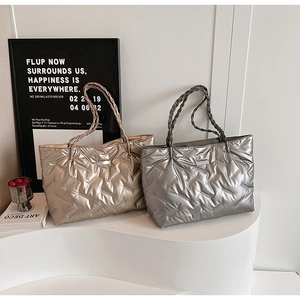 Detail of metallic quilted tote bags in gold and silver with woven rope handles