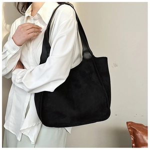 Detailed close-up showing the soft plush suede texture and black leather strap of the tote