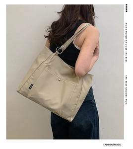 Detail of beige large capacity tote bag with flap pocket and metallic buckle detail