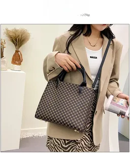 Detailed view of brown geometric tote bag with gold studs and adjustable shoulder strap