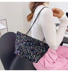 Detail of black sequin crossbody bag with iridescent shimmer and metal chain strap