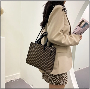 Side view of a vintage geometric pattern tote bag with gold hardware and shoulder strap