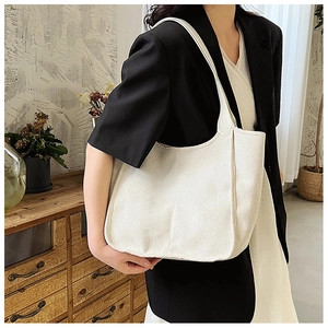 Spacious beige nylon tote bag worn by a model in professional office attire