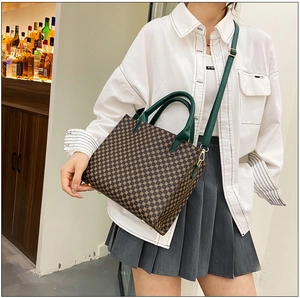 Detailed view of vintage tote bag with retro pattern and dark green leather straps