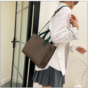 Detailed view of geometric tote bag with green straps and white shirt outfit