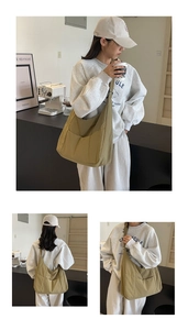 Close-up of olive green nylon tote bag featuring front pockets and wide shoulder strap