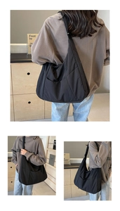 Three-way view of a large black nylon tote bag showing front, side and back on a model