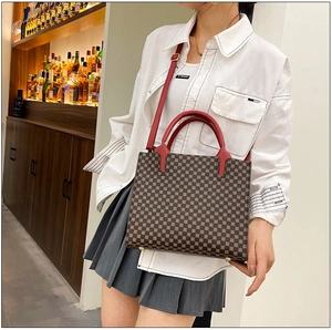 Macro detail of tote bag showing vintage geometric pattern and red leather straps