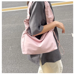 Detail of light pink pleated cloud bag showing wide ruched strap and minimalist side zipper