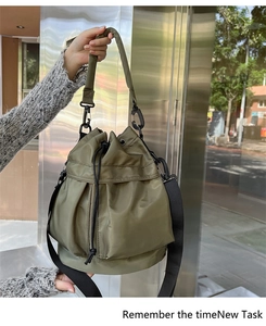Detail of olive green nylon bucket bag with drawstring closure and adjustable strap