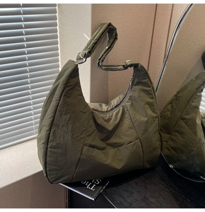 Close-up of olive green quilted nylon hobo bag with adjustable wide strap and zipper detail
