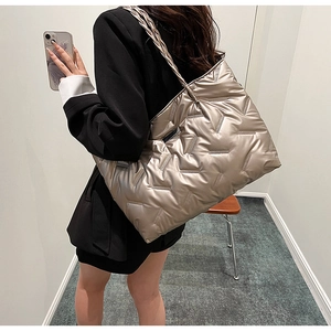 Detailed side view of champagne gold quilted tote bag shown on model for daily commute