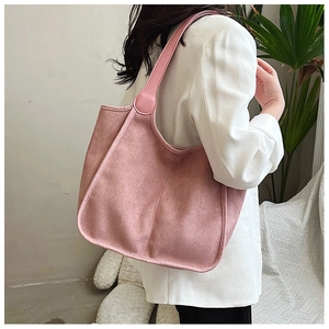 Pink large capacity plush tote bag with long handles styled on a white blazer outfit