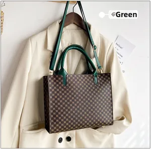 Detail view of vintage tote bag with brown pattern and green leather straps on a suit