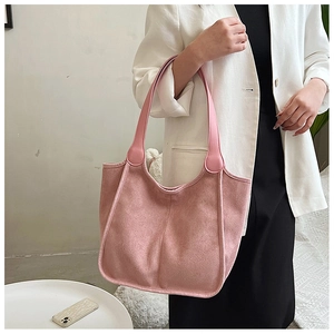 Detail of pink faux suede tote bag featuring vertical stitching and large shoulder strap