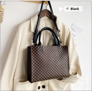Close-up of black leather handles and vintage monogram print on a stylish tote bag