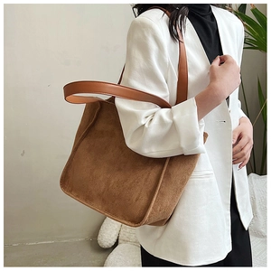 Close-up of deep brown suede tote bag with light brown leather straps on model