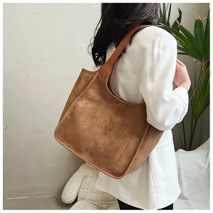 Brown suede tote bag shown on model shoulder for a minimal casual autumn style look