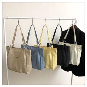 Multiple colorful tote bags hanging in a row showing canvas textures and storage space