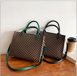 Detail view of structured vintage monogram tote bags with metal feet on wood table