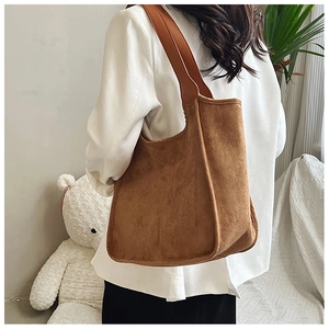 Brown faux suede tote bag shown on model with minimalist high-capacity design