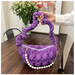 Detailed texture of purple pleated quilted shoulder bag with decorative pearl chain